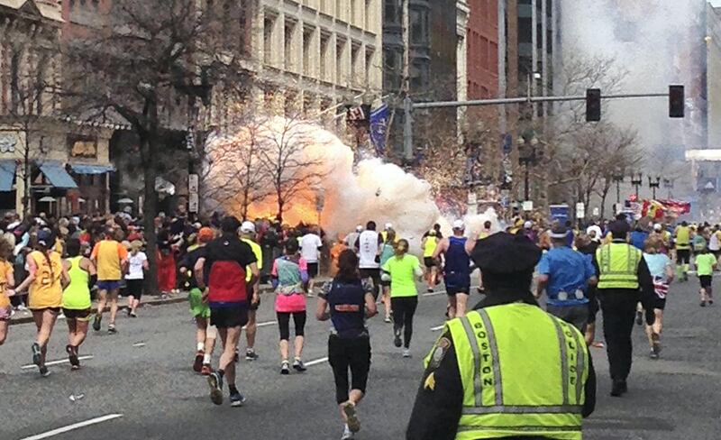 Runners continue to run towards the finish line of the Boston Marathon as an explosion erupts near the finish line of the race in this photo exclusively licensed to Reuters by photographer Dan Lampariello after he took the photo in Boston, Massachusetts, April 15, 2013. Two simultaneous explosions ripped through the crowd at the finish line of the Boston Marathon on Monday, killing at least two people and injuring dozens on a day when tens of thousands of people pack the streets to watch the world famous race.  REUTERS/Dan Lampariello  (UNITED STATES - Tags: CRIME LAW SPORT ATHLETICS) MANDATORY CREDIT