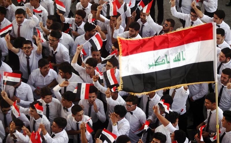 Iraqis wave their country's national fla g as they celebrate in the streets of the holy city of Najaf on July 11, 2017 a day after the government's announcement of the "liberation" of the embattled city of Mosul. - Prime Minister Haider al-Abadi declared Mosul finally retaken on July 10, as his forces fought to recapture a last sliver of territory still held by the jihadists in the Old City on the west bank of the Tigris River. (Photo by Haidar HAMDANI / AFP)