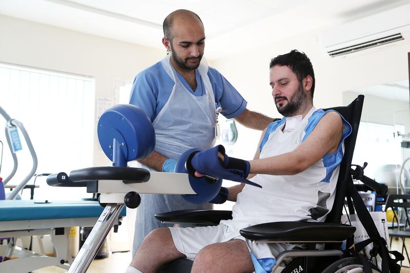 ABU DHABI , UNITED ARAB EMIRATES , JULY 19  – 2017 :- Mohamed Al Hosani ( right ) taking physiotherapy  session from Ahmad Samour , Physiotherapist at the ProVita International Medical Center in Abu Dhabi. ( Pawan Singh / The National ) Story by Shreena Al Nuwais.