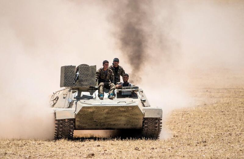 Kurdish YPG fighters drive a tank at the eastern entrances to the town of Tal Abyad, Syria. Rodi Said / Reuters 