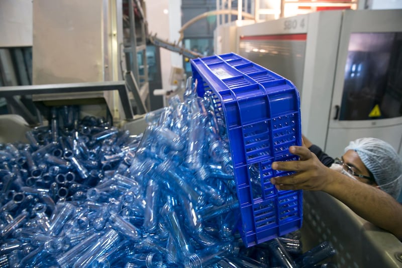 Al AIn, UNITED ARAB EMIRATES, April 8, 2014:   
A production line employee loads up a pile of water-bottle forms inside the blowing room, where bottles get their distinctive shape, as he work at the Al Ain Water bottling facility on Tuesday, April 8, 2014, in Al Ain. (Silvia Razgova / The National)

Reporter:  Thamer Subaihi
Section: National
Usage: April 8, 2014