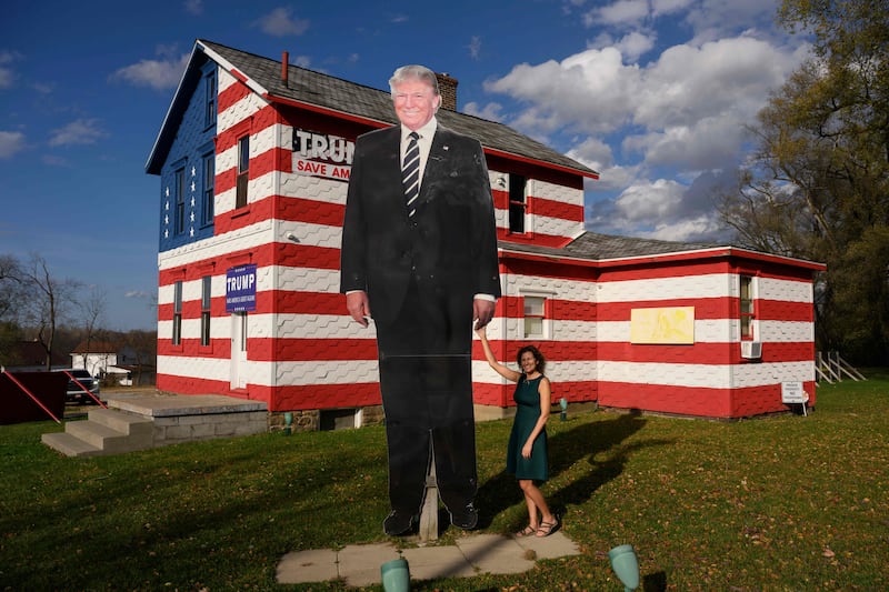 State Representative Leslie Rossi poses by a giant cutout of former US President Donald Trump in front of the "Trump House", which she owns and created in 2016, in Youngstown, Pennsylvania. AFP
