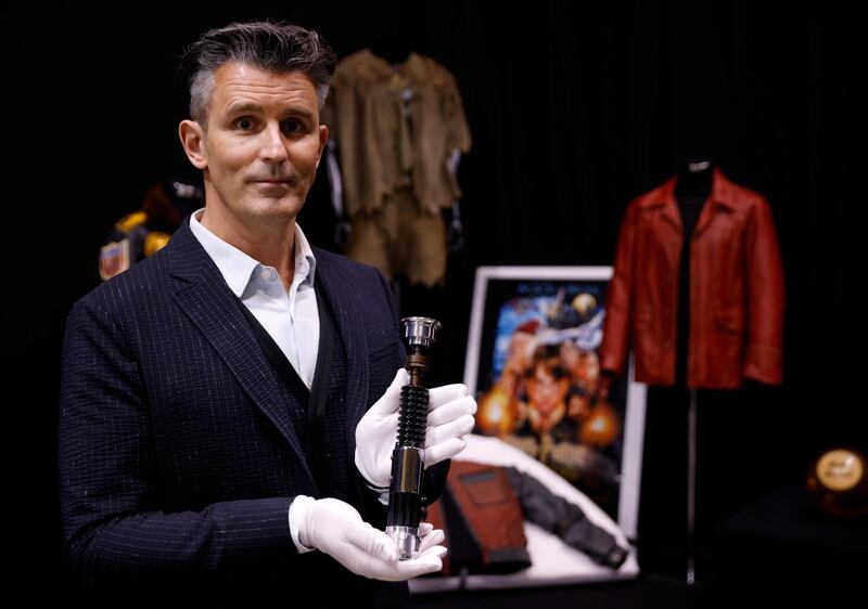 Stephen Lane, chief executive of Prop Store, poses for a photograph with Obi-Wan Kenobi's Hero Lightsaber from 'Star Wars: Revenge of the Sith', at a preview of a movie and TV memorabilia auction. Reuters