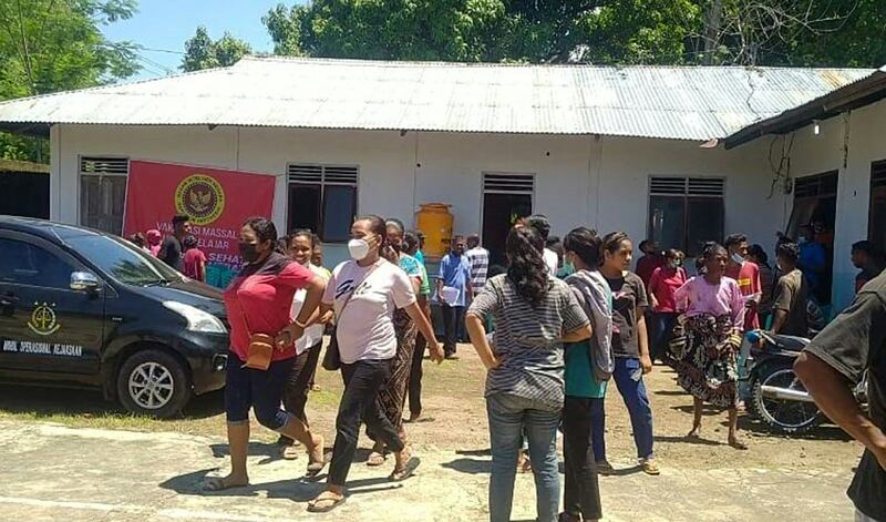 Villagers stand outside a building in Maumere in East Nusa Tenggara on Flores island on December 14, 2021, after a 7. 3-magnitude earthquake struck off the coast in eastern Indonesia.  (Photo by YANUARIUS ARLINO WELIANTO  /  AFP)