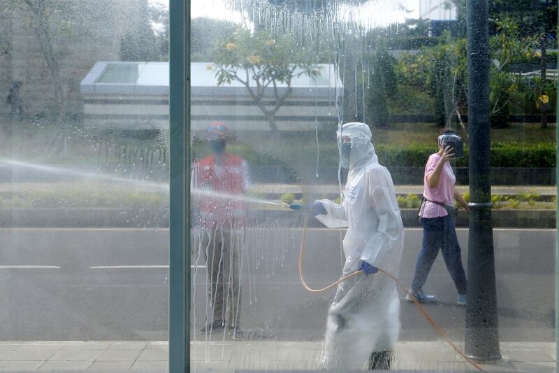 Red cross staff wearing protective suits spray disinfectant in Jakarta, Indonesia. Reuters