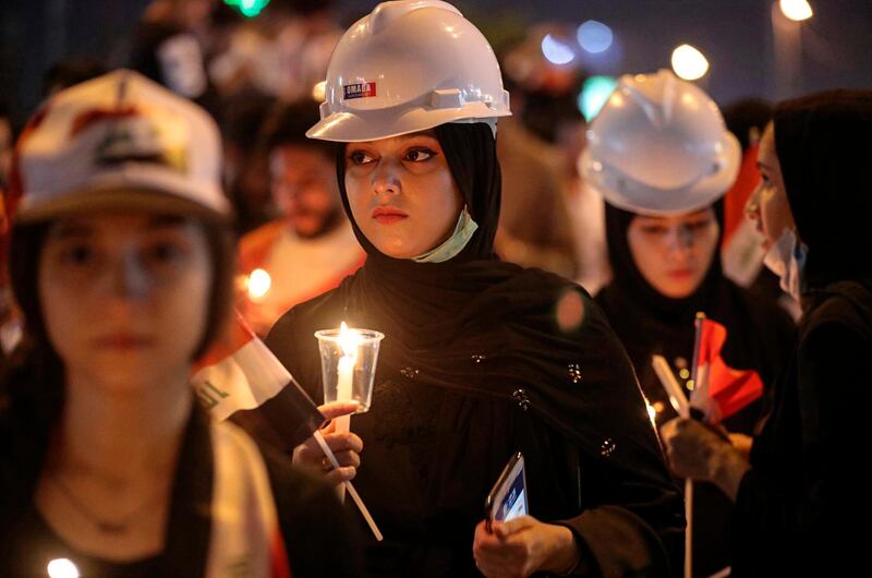 Iraqi women light candles for slain anti-government protesters during ongoing protests in Basra, Iraq. AP Photo