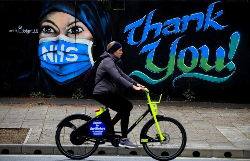 LONDON, ENGLAND  - APRIL 29: A woman cycles past a piece of street art, created by The Artful Dodger, thanking the NHS on April 29, 2020 in London, England. British Prime Minister Boris Johnson, who returned to Downing Street this week after recovering from Covid-19, said the country needed to continue its lockdown measures to avoid a second spike in infections. (Photo by Andrew Redington/Getty Images)