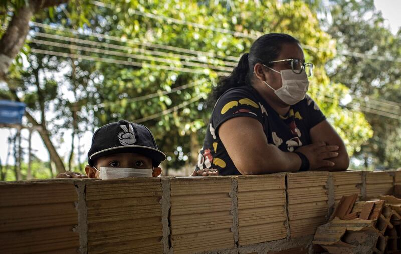 A woman and her son, residents of the Bela Vista do Jaraqui community, struck by the Covid-19 pandemic, use facial masks in the rural area of Manaus, Amazonas, Brazil.  EPA