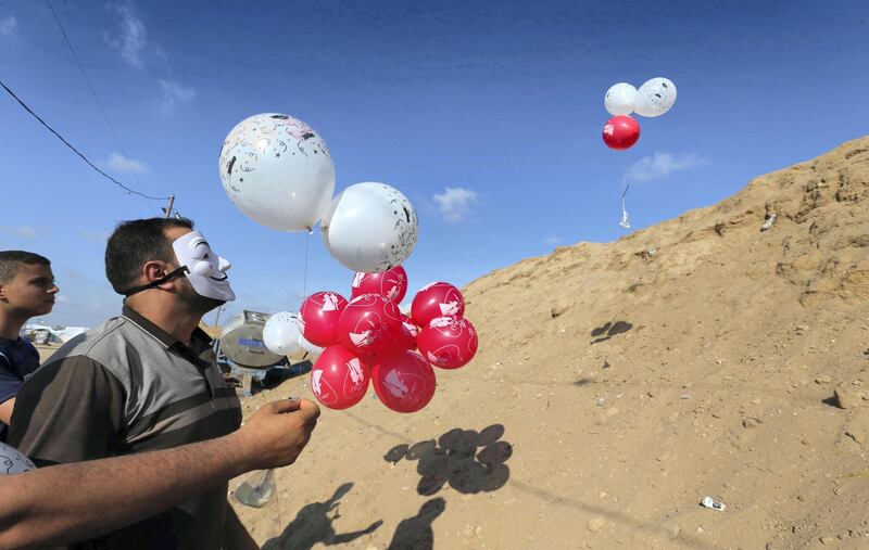 Palestinians fly balloons loaded with flammable material to be thrown at the Israeli side, near the Israel-Gaza border in the central Gaza Strip, June 4, 2018. Picture taken June 4, 2018. REUTERS/Ibraheem Abu Mustafa