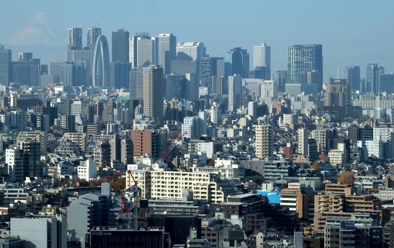 This picture taken on December 3, 2017 shows skyscrapers in Tokyo's Shinjuku area (top) and downtown streets.
Japan is growing twice as fast as previously estimated, official data showed on December 8, 2017, with the world's third-largest economy posting its longest string of gains in more than two decades. / AFP PHOTO / Kazuhiro NOGI
