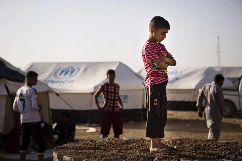 A boy, who fled from the violence in Mosul, stands near tents in a camp for internally displaced people on the outskirts of Erbil, in Iraq's Kurdish region, on June 14. Jacob Russell / Reuters