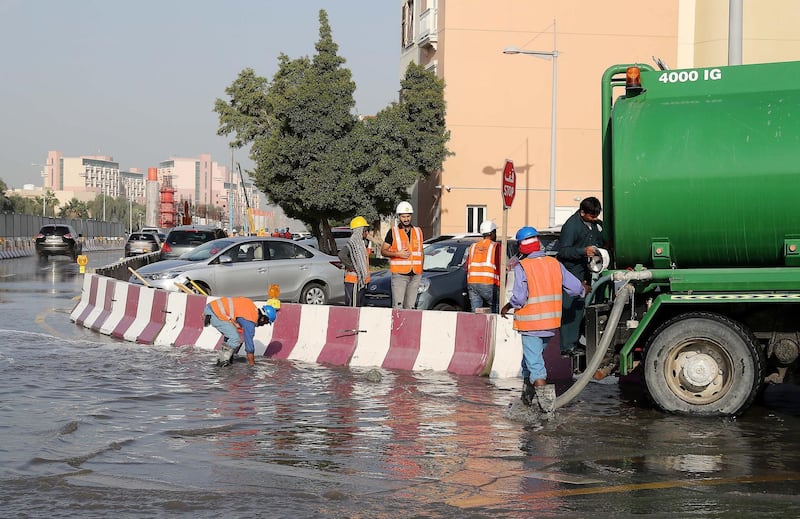 DUBAI , UNITED ARAB EMIRATES , JAN 09 – 2018 :- Workers at the under construction Dubai Metro site pumping out the rain water with the help of water tankers at street 5 in Discovery Gardens area in Dubai.  (Pawan Singh / The National) For News. 