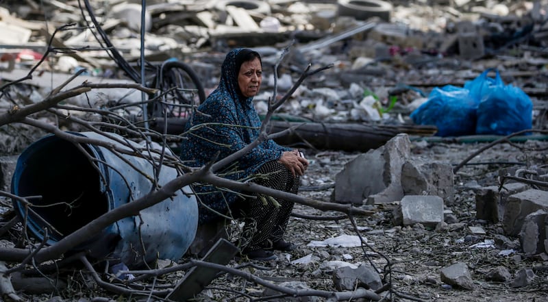 A Palestinian woman sits among the rubble in the destroyed Al-Ramal neighborhood following an Israeli air strike in Gaza City. EPA