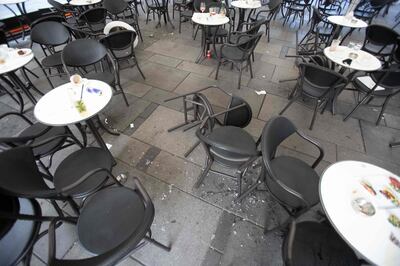 Broken glass is seen on the ground next to chairs and tables of a cafe near Stephansplatz in Vienna on November 3, 2020, after a shooting at multiple locations across central Vienna. Four people were killed in multiple shootings in Vienna on Monday evening, November 2, 2020, in what Austrian Chancellor Sebastian Kurz described as a "repulsive terror attack". / AFP / ALEX HALADA
