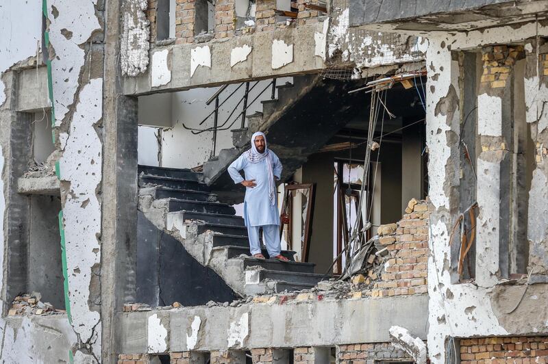 epa07747173 An Afghan man stands on the middle of residential ruined building, in Kabul, Afghanistan, 29 July 2019, a day after a complex suicide attack followed by a fire fight against the office of Afghan former chief of intelligence and current candidate as the first voice president of Ashraf Ghani, in Kabul. According to reports, at least 20 people were killed and 50 others wounded in the incident which targeted the office of Amrullah Saleh.  EPA/HEDAYATULLAH AMID