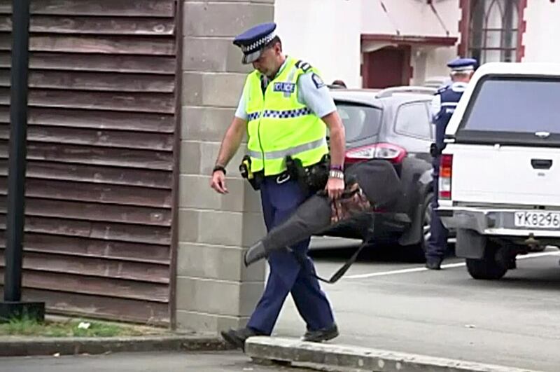 An officer carries a gun voluntarily handed in by a member of the public. TVNZ via AP