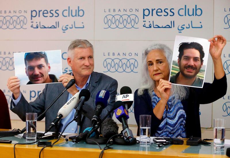FILE - In this July 20, 2017, file photo, Marc and Debra Tice, the parents of Austin Tice, who has been missing in Syria since August 2012, hold up photos of him during a new conference, at the Press Club, in Beirut, Lebanon.   A top Lebanese security official, Maj. Gen. Abbas Ibrahim said Saturday, Nov. 14, 2020,  that after returning from Washington recently he visited Syria for two days where he spoke with officials about American journalist Austin Tice who has been missing in the war-torn country since 2012.   (AP Photo/Bilal Hussein, File)