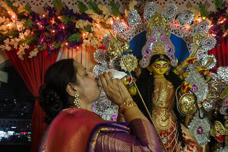 A devotee performs a ritual in front of the idol of Durga during Navratri and Durga puja celebrations in Ahmedabad. AFP