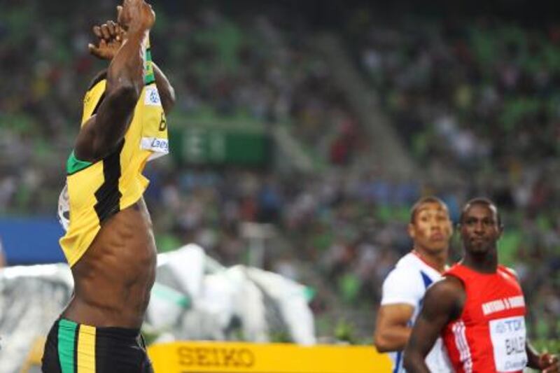 epa02885099 Usain Bolt (L) of Jamaica pulls his shirt over his head after making a false start in the men's 100m final at the 13th IAAF World Championships in Daegu, Republic of Korea, 28 August 2011. The defending champion and world record holder was disqualified from the final.  EPA/RUNGROJ YONGRIT *** Local Caption ***  02885099.jpg