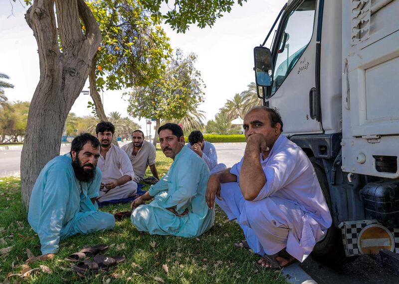 Abu Dhabi, United Arab Emirates, June 15, 2019.  
The UAE's mandatory midday break for people working outdoors during the summer months will come into force on Saturday. --  Pakistani truck drivers take refuge under the shade of a tree along Al Dhafra road.
Victor Besa/The National
Section:  NA
Reporter: