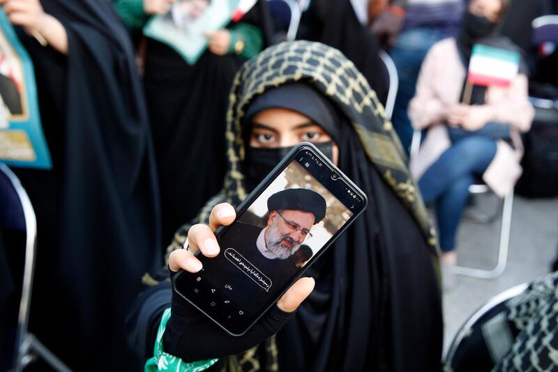 A woman shows an image of  Iranian president-elect Ebrahim Raisi on her phone. He received 17.9 million votes in a landslide victory. EPA