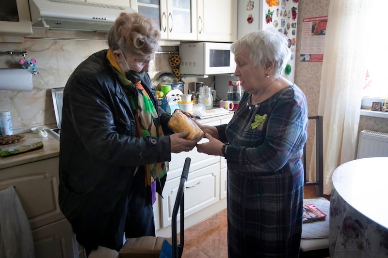 St Petersburg resident Lyubov Travkina, 83, receives supplies from Galina Yakovleva. AP Photo