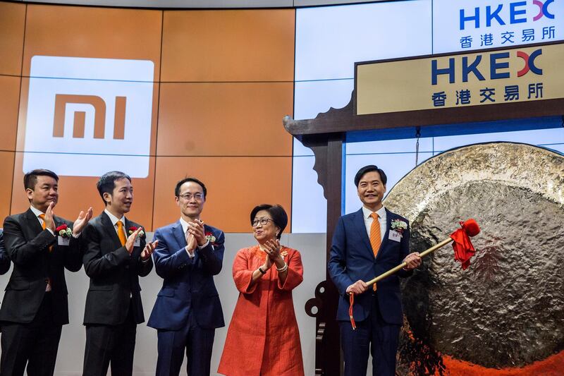 Xiaomi founder, chairman and CEO, Lei Jun (R), hits a gong at the company's initial public offering (IPO) launch on the Hong Kong Stock Exchange in Hong Kong on July 9, 2018.
Chinese smartphone giant Xiaomi kicked off its trading debut in Hong Kong on July 9, a long-awaited IPO overshadowed by the start of a US-China trade war and bearish investor sentiment. / AFP PHOTO / ISAAC LAWRENCE