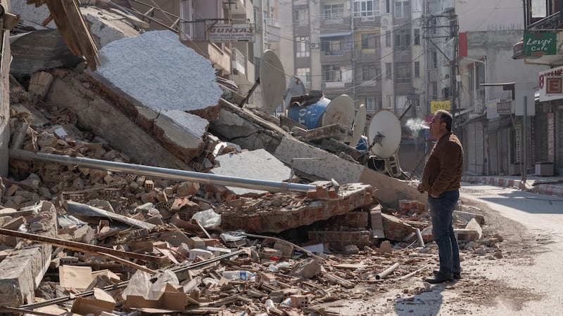 A man stands outside what was once his clothing shop