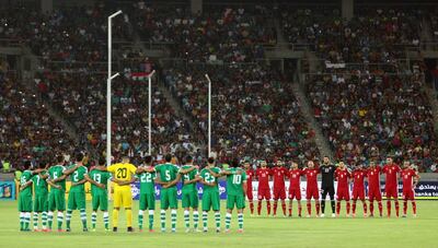 Iraq and Jordan playes observe a moment of silence ahead of a friendly at Basra in June. Football is being played across Iraq. Haider Mohammed Ali / AFP
