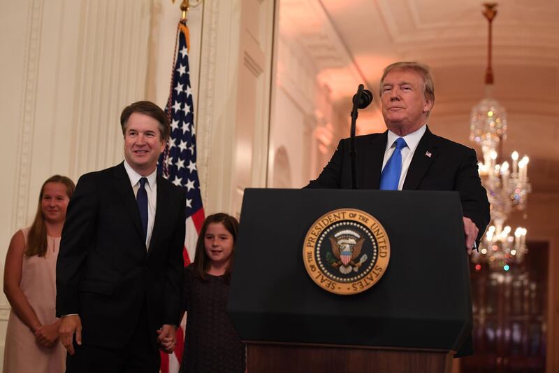 US President Donald Trump (R) announces US Judge Brett Kavanaugh (C) as his nominee to the Supreme Court in the East Room of the White House on July 9, 2018 in Washington, DC.  / AFP / SAUL LOEB
