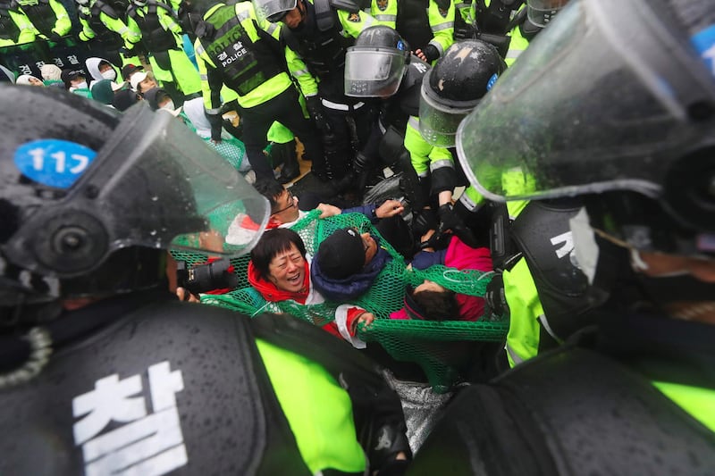 Riot police remove South Korean protesters opposing the deployment if a US THAAD system from blocking the road in Seongju. Yonhap / AFP Photo