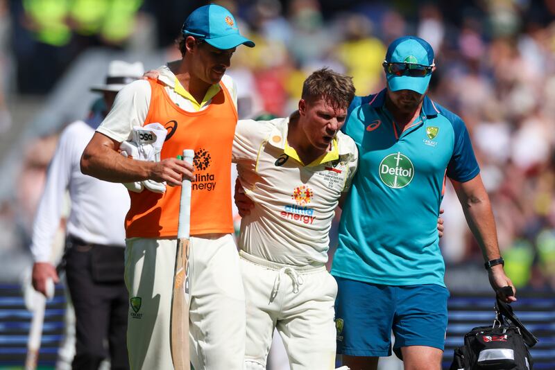 David Warner is assisted from the field as he retires injured after reaching 200 runs. AP