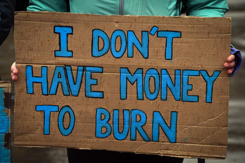 A demonstrator holds a placard during a march organised by The People's Assembly to demand action to tackle the cost-of-living crisis in the UK. AFP