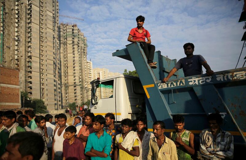 Residents watch rescuers work at the site of a building collapsed in Shahberi village. AP Photo