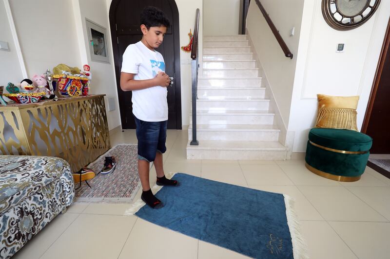 Rayyan Mostafa, 9, performing his prayers at home in Dubai.