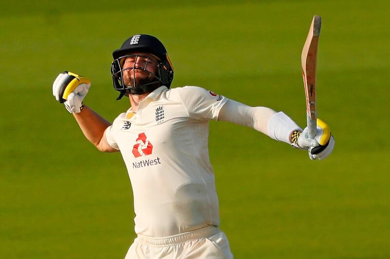 Chris Woakes celebrates after hitting the winning runs during play on the fourth day of the first Test match between England and Pakistan at Old Trafford in Manchester. AFP