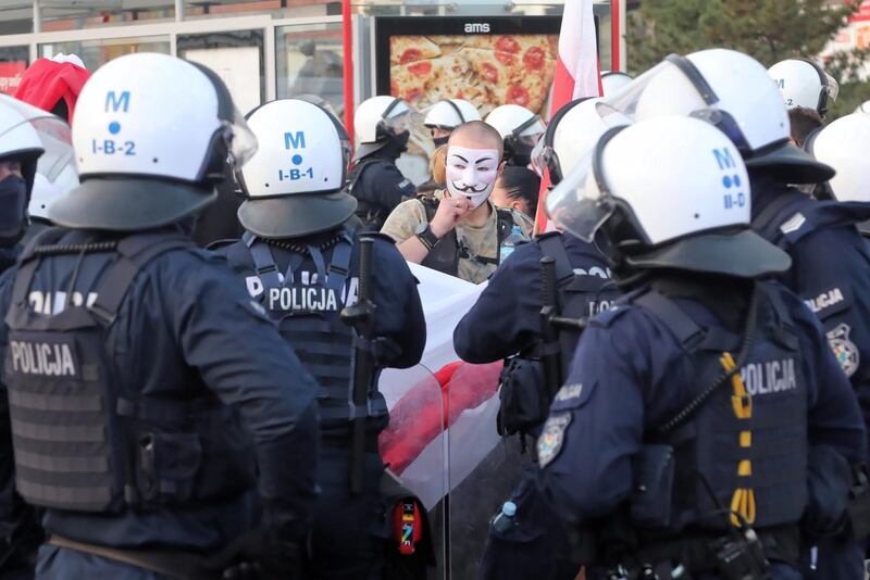 People clash with the police during their protest against new coronavirus restrictions in Warsaw, Poland. EPA
