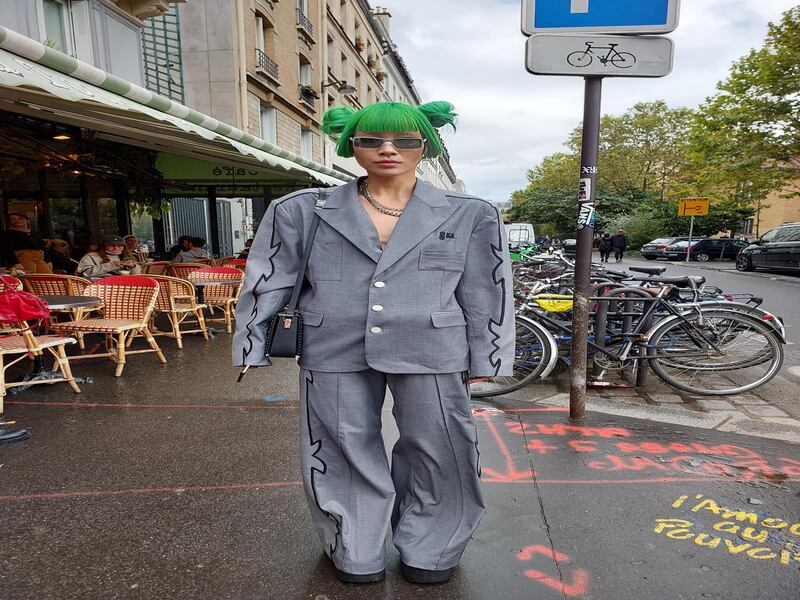 An oversized grey suit and green hair, in the rain.
