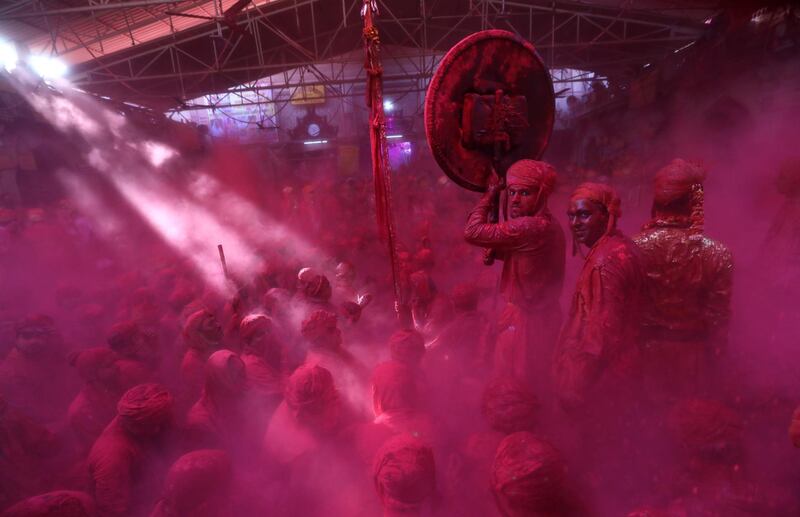 Hindu men from the villages of Nandgaon and Barsana are covered with colored powder for the Lathmar Holi festival at the Radha Rani temple in Barsana village, Mathura, India.  EPA