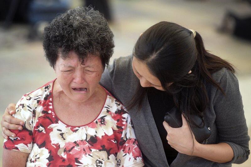 A woman is comforted by hospital staff as she cries at Singapore General Hospital where former prime minister Lee Kuan Yew passed away in Singapore. Joseph Nair / AP Photo