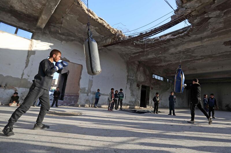 Syrian youths take part in a boxing workout held by local boxer Ahmad Dwara (unseen) inside a damaged building in the town of Atareb in the rebel-held western countryside of Syria's Aleppo province. AFP