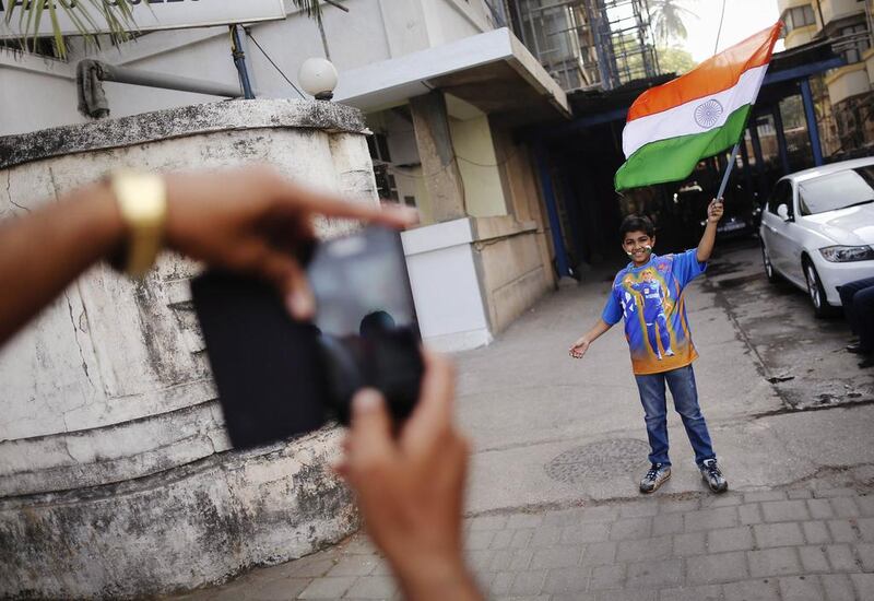 A young India fan poses with a flag and a shirt with Sachin's image on it. Danish Siddiqui / Reuters