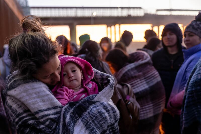 Migrants try to keep warm at the US border with Mexico. Getty / AFP