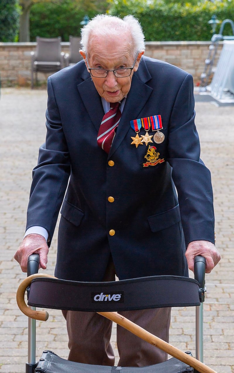 A handout photo taken in April 2020, and released by the Maytrix Group in London on April 14, 2020, shows World War Two (WWII) veteran 99-year-old Captain Tom Moore walking in his garden in Marston Moretaine, north of London, to raise money for Britain's National Health Service (NHS). A 99-year-old British World War II veteran on Tuesday had raised over £1.5 million ($1.9 million) for health workers on the coronavirus front-line, crashing the donation website hosting his appeal. Tom Moore, a captain who served in India, is being sponsored to complete 100 lengths of his 25-metre garden, with the aid of a frame, in time for his 100th birthday at the end of the month. He originally planned to raise £1,000 for a National Health Service charity after receiving treatment for a broken hip and cancer. But he has now smashed the million mark and completed 70 laps of his garden in Bedfordshire, south England. - RESTRICTED TO EDITORIAL USE - MANDATORY CREDIT "AFP PHOTO / MAYTRIX GROUP / HANDOUT " - NO MARKETING - NO ADVERTISING CAMPAIGNS - DISTRIBUTED AS A SERVICE TO CLIENTS
 / AFP / MAYTRIX GROUP / - / RESTRICTED TO EDITORIAL USE - MANDATORY CREDIT "AFP PHOTO / MAYTRIX GROUP / HANDOUT " - NO MARKETING - NO ADVERTISING CAMPAIGNS - DISTRIBUTED AS A SERVICE TO CLIENTS
