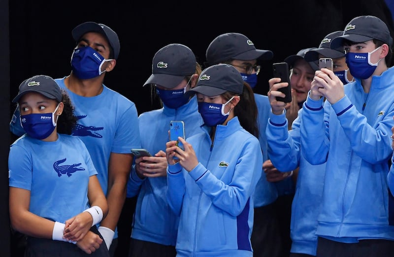 Ball boys and ball girls take pictures on their phones after Spain's Rafael Nadal win his group stage match against Russia's Andrey Rublev. Reuters