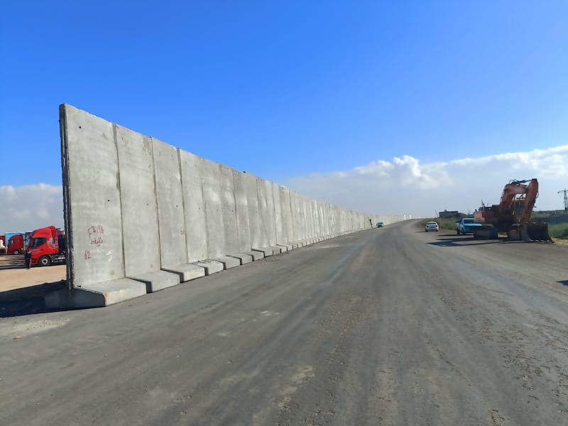 Lorries park near a newly constructed wall in Al Masoura, Egypt, 3km from the Rafah border crossing into Gaza, on February 17. EPA