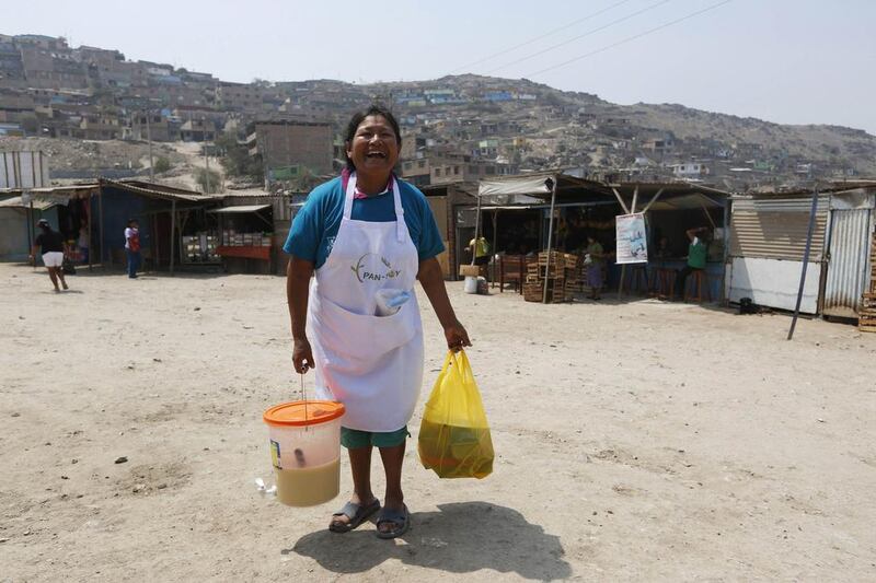 Honorata Huaman poses with cakes and soy juice which she sells in Gosen City. Huaman makes a living selling cakes, and uses most of her profits to help poor children in the neighbourhood. Mariana Bazo / Reuters