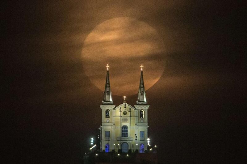 The full moon descends behind the Nossa Senhora da Penha Church in Rio de Janeiro, Brazil. At this time of the year the moon is at the closest point to the earth. Experts name this phenomenon the supermoon or perigee. Yasuyoshi Chiba / AFP Photo