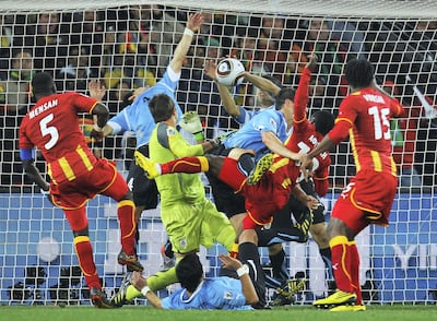JOHANNESBURG, SOUTH AFRICA - JULY 02:  Dominic Adiyiah of Ghana heads the ball towards goal and Luis Suarez of Uruguay handles the ball off the line during the 2010 FIFA World Cup South Africa Quarter Final match between Uruguay and Ghana at the Soccer City stadium on July 2, 2010 in Johannesburg, South Africa.  (Photo by Paul Gilham - FIFA/FIFA via Getty Images)