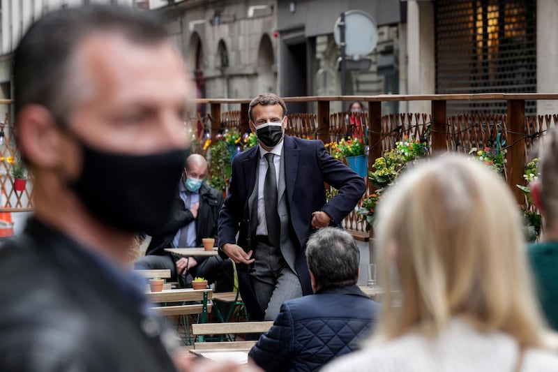 Emmanuel Macron leaves after his coffee in Paris. Groups of up to six people can now meet outside cafes and restaurants. AFP